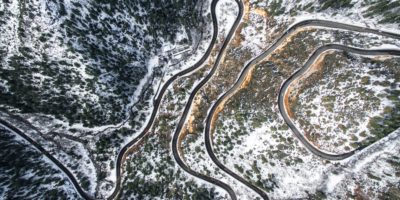 Aerial shot of a road snaking across a winter landscape.