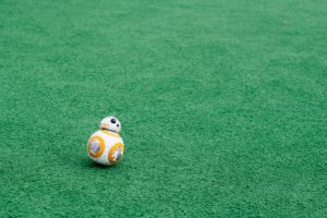 BB-8 Robot from the film Star Wars: The Force Awakens moving across a green carpet.