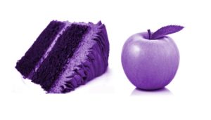 A purple coloured slice of cake next to a purple coloured apple.
