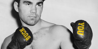 A boxer with the words "you" and "suck" on his gloves.