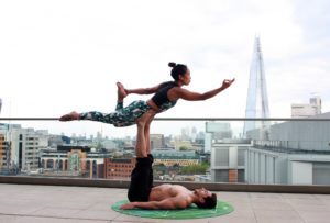 A man and a woman doing a yoga pose.