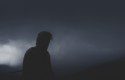 Silhouette of a man standing in thick fog.