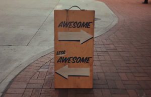 Sign that says awesome with an arrow pointing one way, and less awesome with an arrow pointing the other way