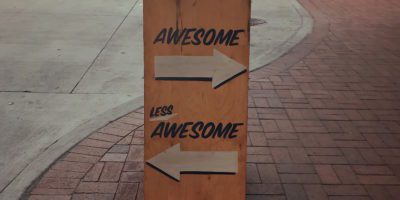 Sign that says awesome with an arrow pointing one way, and less awesome with an arrow pointing the other way