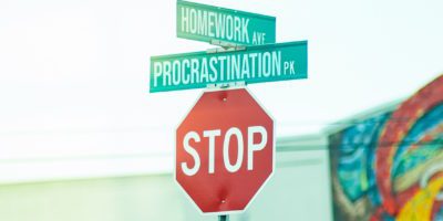 Stop sign with street signs for Homework Avenue and Procrastination Park above it