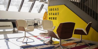 The words 'ideas start here' in black text on a yellow wall.