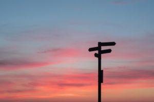 A signpost against a sky at sunset.