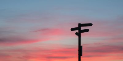A signpost against a sky at sunset.